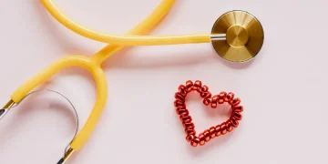 Qualifying life events for health insurance: stethoscope and red heart symbol on pink background.